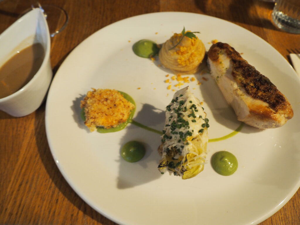 Garlic Roasted Chicken "Caesar", with a breast, leg and anchovy pressing, charred gem lettuce, smoked bacon mash and a crispy yolk.